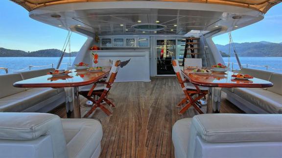 The aft deck of Angelo 2 features a spacious dining area and a bar.