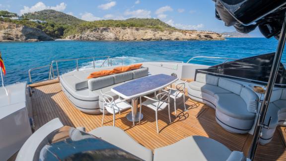 The aft deck of motor yacht Five Stars features a spacious seating area and a dining table.