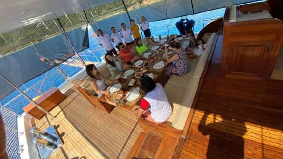 Familie und Freunde genießen ein gemeinsames Essen auf der Gulet Mrs. Elcih in Göcek, Türkei.