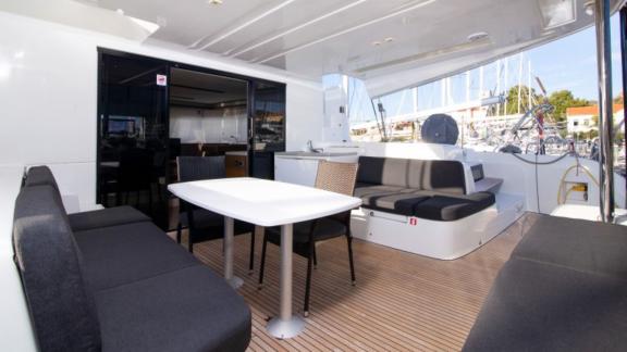 The cockpit of Lagoon 50 offers a spacious seating area with a dining table and comfortable sofas, perfect for outdoor m