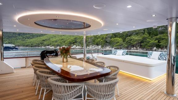 The stylish dining area on Nocturno's deck with views of the green coastline.