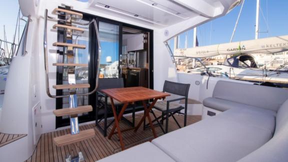 The aft deck of motor yacht Brigadoon features a comfortable seating area with a table and chairs.