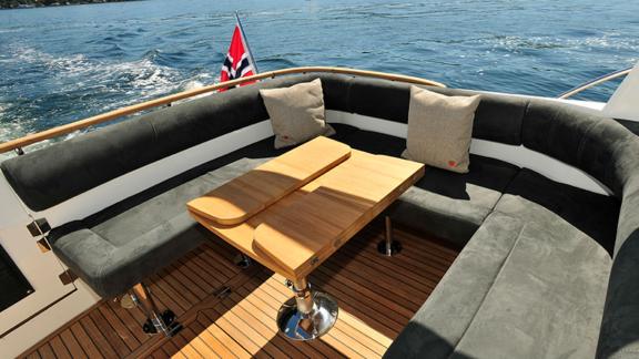 Gemütliche Sitzecke mit Holztisch auf dem Achterdeck der Motoryacht North Star.