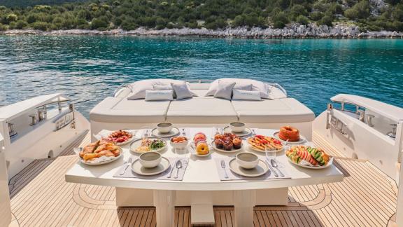 A table laden with a variety of breakfast items on the For Ever yacht, by the sea.