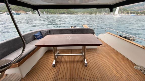 Der Sitz- und Essbereich auf dem Heck der Motoryacht Niloş bietet eine entspannte Erfahrung mit Blick auf das Meer.