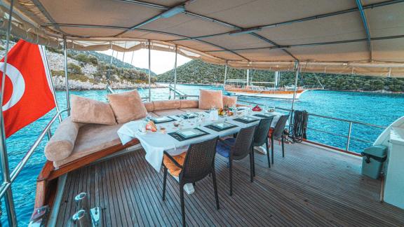 Covered dining area on the deck of Gulet Azura with comfortable seating and scenic view of Göcek.