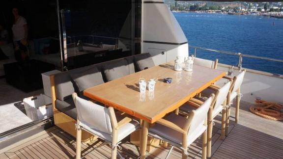 Achterdeck der Motoryacht Kuum mit komfortabler Sitzecke und Esstisch.