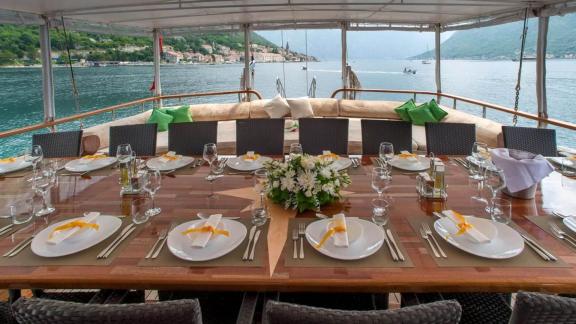 Stylishly set dining table on a Gulet yacht, surrounded by stunning sea scenery. Luxurious dining experience.