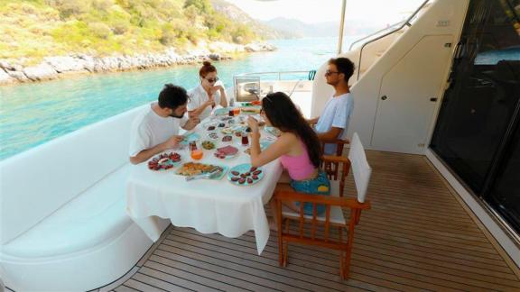 Enjoy a delightful meal with friends on the aft deck of motor yacht Bormus 2 with a sea view.