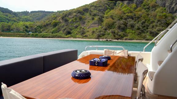 The large dining table on the aft deck of Alfa F yacht offers enjoyable meals with a view of nature.