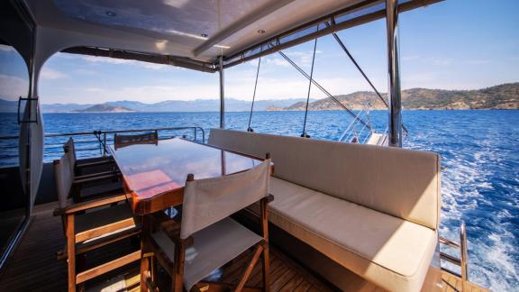 Auf dem Achterdeck der Motoryacht Imperial befindet sich ein Essbereich mit Meerblick.