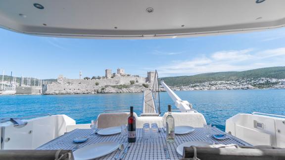 Dining table on the aft deck of the motor yacht Queen with a view of Bodrum Castle.