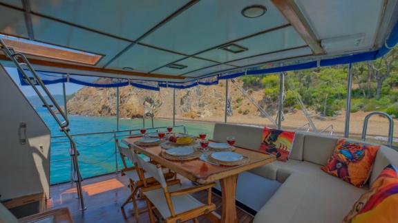 Stylish dining table on the aft deck of the trawler Grainne Mhaol with nature views.