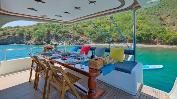 An invitingly set dining table on Gulet Anes, perfect for meals in a tranquil bay with a view of the water.