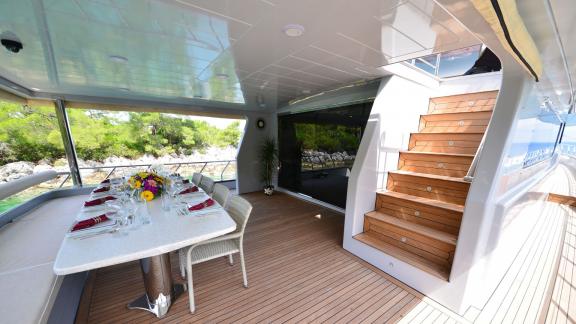 The aft deck of Simay F yacht features a stylish dining area with comfortable seating and a scenic view.