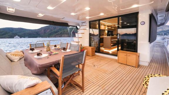 The aft deck features an elegant dining area with a sea view.