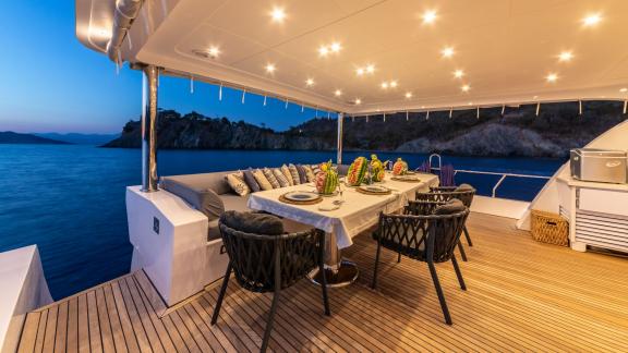 The lit dining area of Floki trawler yacht offers an ideal setting for evening dinners.