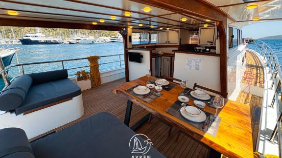 The elegant dining table on the aft deck of Gulet Ayken offers a delightful dining experience with a sea view.