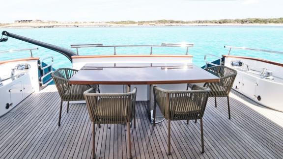 The aft deck of Lady KC features a stylish dining area with a sea view.