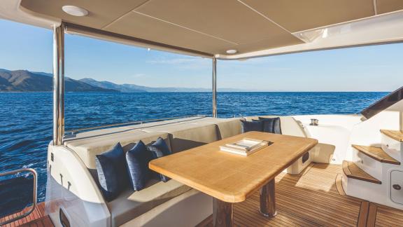 The aft seating area of Emilia 2 features a cozy table and scenic sea view.