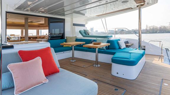 The aft deck of catamaran Happy features cozy seating and tables, perfect for relaxing outdoors.