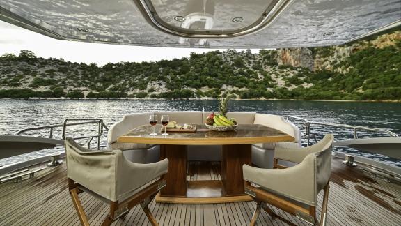 The dining area on the aft deck of Stela 117 offers comfortable seating with views of nature.