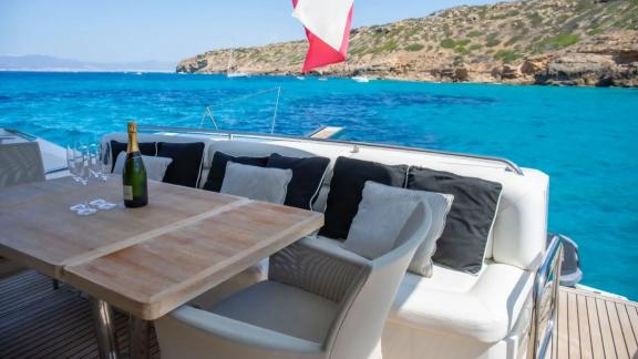 Dining area on Midnight Summer Dream yacht with table, seating, and sea view.