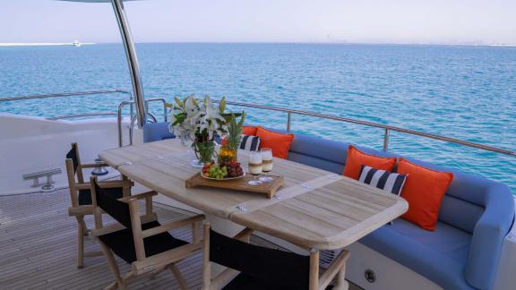 The dining area on the deck of the Notorious motor yacht offers a luxurious and peaceful setting for yacht rental in Dub