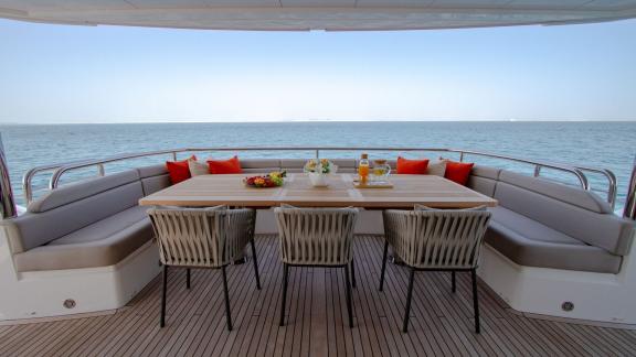 The dining table on the deck of the Legende motor yacht offers style and comfort for your Dubai yacht rental experience.