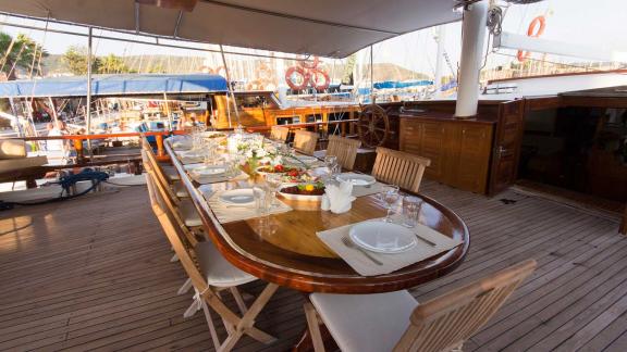 Genießen Sie ein elegantes Dinner an Bord der Gulet Harmonia mit einem wunderschön gedeckten Tisch im Hafen von Zakyntho