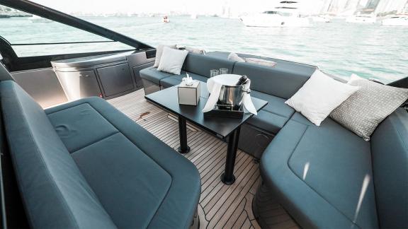 Relax in the spacious open seating area of Pershing 5X Grey with Dubai motor yacht rental services.