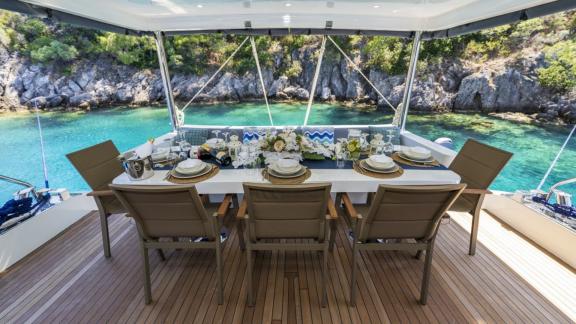 Elegant dining table on the aft deck of Oggusto yacht anchored in Fethiye bays.