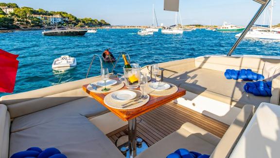 The aft area of Parodia II in Mallorca features a set table with sea view and cushioned seating.
