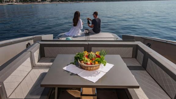 A couple enjoys drinks and sea views on the back of a luxury yacht off the coast of Mallorca.