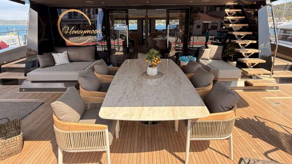 Das Heckdeck des Katamarans Honeymoon bietet bequeme Sitzplätze und einen großen Esstisch.