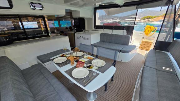 Zalina’s aft deck features grey cushioned seating and a set dining table.