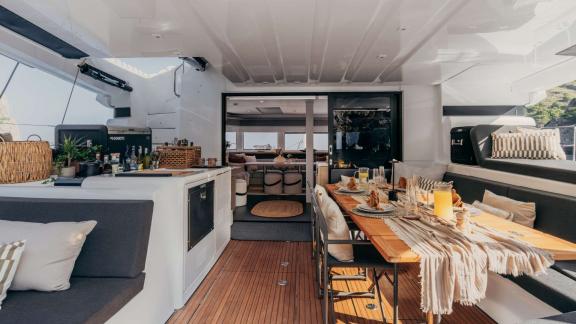 Set table and drink station on deck with the yacht’s salon visible inside.