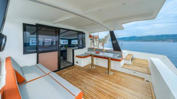 В Сплите на катамаране Orange мягкие сиденья, стол и рулевое место на корме.