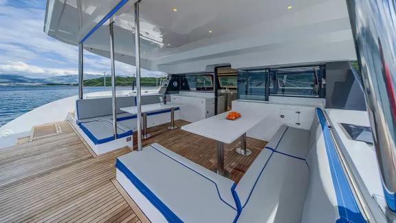Luna 49 Blue’nun arka güvertesi, açık deniz manzaralı minderli oturma grubu ve yemek masasıyla konfor sunuyor.