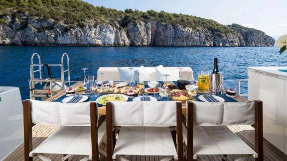 The aft deck of Sunreef 50 Solitaire features a beautifully set table with sea views for a memorable meal.