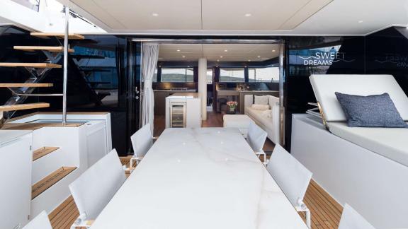 На корме катамарана мраморный стол и удобная зона для загара.