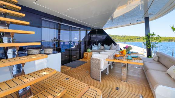 The shaded dining area on Honeybird’s aft deck offers a scenic and relaxing charter experience in Šibenik.