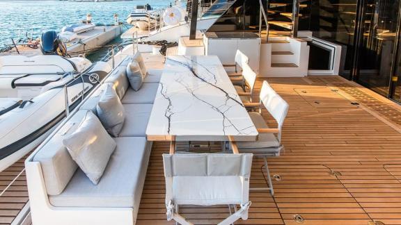 Enjoy serene meals on the aft deck of Sunreef 60 Mr. Si, featuring a modern dining table and waterfront scenery.