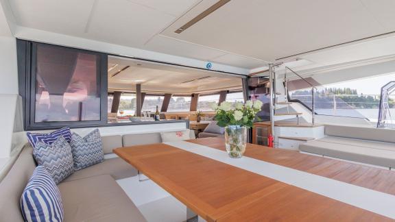 The Power 67 Ariva anchored in Corfu offers a cozy seating area with a large table and open-flow salon design.