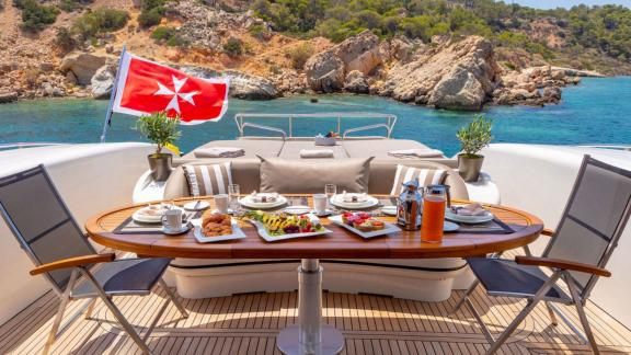 Enjoy a delicious breakfast on Cosmos with panoramic views of rocky shores and turquoise waters.