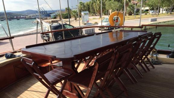 The spacious dining table on the aft deck of Gulet Aurora is perfect for outdoor meals with a sea view.