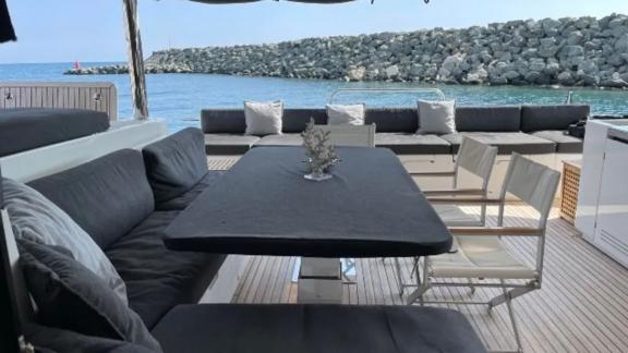 Cozy outdoor seating area with dining table and cushioned benches on Lagoon 630 Pearly Gates, overlooking the sea in Lav