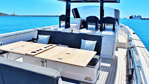 The motor yacht Celebrate offers a comfortable seating area with a wooden table for perfect outdoor dining.