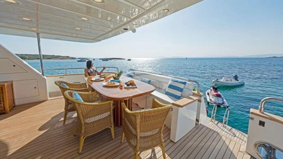 Ein gedeckter Frühstückstisch auf dem Deck der Illya F Yacht mit Blick auf das Meer.