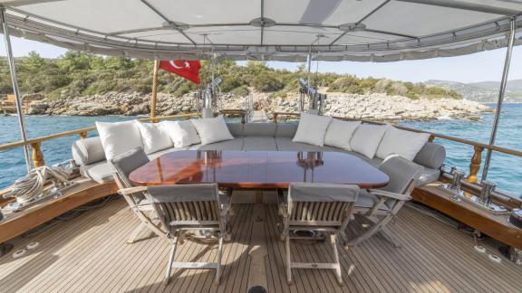 Outdoor dining area of a sailing yacht with table, chairs and cushions off the coast of Bodrum.